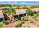 Aerial view of a desert home with lush landscaping, stone terracing, and backyard seating at 522 Via Ventana Dr, Mesquite, NV 89027