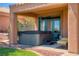 Covered backyard patio features a hot tub and a seating area at 522 Via Ventana Dr, Mesquite, NV 89027