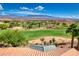 Expansive golf course view with lush greenery and mountain backdrop from the home's red tile roof at 522 Via Ventana Dr, Mesquite, NV 89027