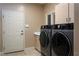 Laundry room with modern washer and dryer and storage cabinets at 522 Via Ventana Dr, Mesquite, NV 89027
