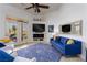 Inviting living room with blue sofa, white chairs, fireplace, TV, and patio access at 522 Via Ventana Dr, Mesquite, NV 89027