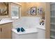 Main bathroom soaking tub with a window and decorative tile surround at 522 Via Ventana Dr, Mesquite, NV 89027
