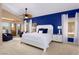 Bright main bedroom with a ceiling fan, blue accent wall, balcony access, and ensuite bathroom at 522 Via Ventana Dr, Mesquite, NV 89027