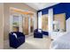 Main bedroom sitting area with two blue comfy chairs, white walls, and glass doors to the outside at 522 Via Ventana Dr, Mesquite, NV 89027