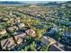 An aerial view shows a well-kept community with neatly arranged homes, lush trees, and a park nearby at 5225 Villa Dante Ave, Las Vegas, NV 89141