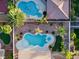 A bird's eye view of two backyard swimming pools and meticulously landscaped yards with desert landscaping and palm trees at 5225 Villa Dante Ave, Las Vegas, NV 89141