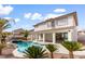 An exterior shot of a backyard with pool, spa, rock landscaping, and covered patio at 5225 Villa Dante Ave, Las Vegas, NV 89141