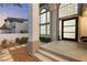 This home has a modern front entry with tall windows, a high ceiling, an inviting porch, and tasteful landscaping at 5225 Villa Dante Ave, Las Vegas, NV 89141