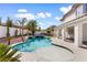 A stunning backyard featuring a pool with a waterfall feature and covered patio at 5225 Villa Dante Ave, Las Vegas, NV 89141