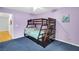 A bedroom featuring cozy bunkbeds, soft blue carpet, and calming purple walls at 544 N Fogg St, Las Vegas, NV 89110