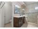 Bathroom featuring a dark wood vanity, a shower with glass doors, and modern fixtures at 6292 Belgium Dr, Las Vegas, NV 89122