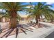 Charming single-story home with mature palm trees accentuating desert landscaping and a two car garage at 6292 Belgium Dr, Las Vegas, NV 89122