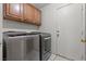 Laundry room with a washer, a dryer, upper storage cabinets and a tile floor at 6292 Belgium Dr, Las Vegas, NV 89122