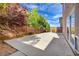 An open backyard features a concrete patio area, block wall surround, and mature trees for pleasant outdoor living at 6402 Parrot Ridge Ct, Las Vegas, NV 89139