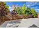 The backyard features a concrete patio area, mature trees along the block fence, and access to the home at 6402 Parrot Ridge Ct, Las Vegas, NV 89139