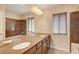 Bathroom featuring double sinks, a bathtub-shower, and a large vanity mirror at 6402 Parrot Ridge Ct, Las Vegas, NV 89139