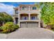 Elegant two-story home featuring a three-car garage, beautiful balconies, and a well-manicured front yard at 6402 Parrot Ridge Ct, Las Vegas, NV 89139