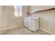 Bright laundry room with washer, dryer, shelf, and a window at 6402 Parrot Ridge Ct, Las Vegas, NV 89139