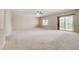 Spacious living room with neutral carpet, recessed lighting, and sliding glass doors leading to the outside balcony at 6402 Parrot Ridge Ct, Las Vegas, NV 89139