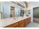 Bright bathroom featuring double sinks, a large mirror, and wood cabinetry at 7076 Oakleigh Dr, Las Vegas, NV 89110