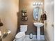 Well-maintained half bathroom, featuring a pedestal sink, updated toilet, and neutral decor at 7076 Oakleigh Dr, Las Vegas, NV 89110
