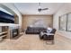Comfortable living room featuring a fireplace, large windows, and a ceiling fan at 7076 Oakleigh Dr, Las Vegas, NV 89110