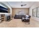 Comfortable living room featuring a fireplace, large windows, and a ceiling fan at 7076 Oakleigh Dr, Las Vegas, NV 89110