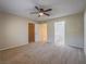 Large bedroom with plush carpeting, a ceiling fan, and access to a walk-in closet and bathroom at 713 Wheat Ridge Ln # 102, Las Vegas, NV 89145