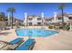 Inviting community pool surrounded by lounge chairs and lush landscaping at residential complex at 713 Wheat Ridge Ln # 102, Las Vegas, NV 89145