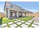 Well-maintained backyard with artificial turf, a covered patio, and a stylish geometric paver design at 7456 Tinley Creek Ave, Las Vegas, NV 89113