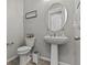 Cozy half-bathroom with stylish fixtures, a pedestal sink, and modern accessories at 7456 Tinley Creek Ave, Las Vegas, NV 89113