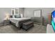 This bedroom is bright and features a cushioned bench, plush carpet, and gray furniture at 7456 Tinley Creek Ave, Las Vegas, NV 89113