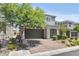 Charming two-story home featuring a gray facade, manicured landscaping, and a brick driveway at 7456 Tinley Creek Ave, Las Vegas, NV 89113
