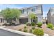 Charming two-story home featuring a gray facade, manicured landscaping, and a brick driveway at 7456 Tinley Creek Ave, Las Vegas, NV 89113