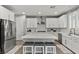 Bright kitchen with white cabinets, stainless steel appliances, and a center island with seating at 7456 Tinley Creek Ave, Las Vegas, NV 89113