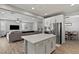 Open concept living room, featuring a modern kitchen island connected to a seating and dining area at 7456 Tinley Creek Ave, Las Vegas, NV 89113