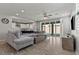 Bright, open-concept living room featuring a plush sectional sofa, modern ceiling fan, and sliding glass doors at 7456 Tinley Creek Ave, Las Vegas, NV 89113