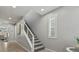 Carpeted staircase leading to the upper level, complemented by natural light from a nearby window at 7456 Tinley Creek Ave, Las Vegas, NV 89113
