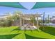Backyard featuring artificial grass, a covered dining area, and a trampoline at 747 Canyon Crest Dr, Las Vegas, NV 89123