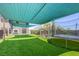 Spacious backyard featuring artificial grass, a covered dining area, and a trampoline at 747 Canyon Crest Dr, Las Vegas, NV 89123