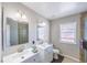 Modern bathroom featuring double sinks, tile flooring, shower stall, and ample natural light at 747 Canyon Crest Dr, Las Vegas, NV 89123