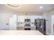 Updated kitchen features white cabinets, modern hardware, stainless steel appliances, and a large island with quartz countertops at 747 Canyon Crest Dr, Las Vegas, NV 89123