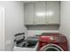 Convenient laundry area equipped with modern washer and dryer, and storage cabinets for organization at 747 Canyon Crest Dr, Las Vegas, NV 89123