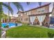 Beautiful backyard with a refreshing pool, green grass, palm trees, and a shaded pergola at 7908 Horse Bridle St, Las Vegas, NV 89131