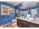 Well-lit bathroom showcasing a double sink vanity, bright blue walls, and tasteful decor at 7908 Horse Bridle St, Las Vegas, NV 89131