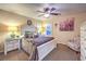 Cozy bedroom with lots of light, a ceiling fan, stylish chair and colorful wall art at 7908 Horse Bridle St, Las Vegas, NV 89131