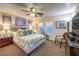 Comfortable bedroom with a ceiling fan, cozy lamps, soft lighting, and a stylish zebra chair at 7908 Horse Bridle St, Las Vegas, NV 89131