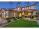 This two-story home features lush landscaping, exterior lighting, and a charming fountain feature at 7908 Horse Bridle St, Las Vegas, NV 89131