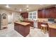 Traditional kitchen features a center island, tile floors, and cherry wood cabinets at 7908 Horse Bridle St, Las Vegas, NV 89131