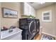 Efficient laundry room featuring modern washer and dryer set, ample cabinet space, and utility sink at 7908 Horse Bridle St, Las Vegas, NV 89131